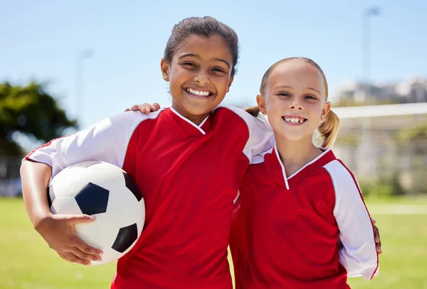 Portrait of girls on field, sports and soccer player, smiling with teammate. Soccer ball, football and young kids having fun on summer day before match or game. Team, friends and teamwork in sport.