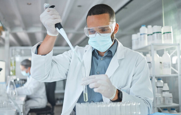 Covid, scientist man and vaccine research with medicine analysis test tube and chemical pipette in a science lab. Medical development, cure and an expert working on new virus cure in laboratory.