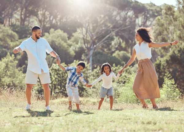 Freedom, happy family and fun in a park with black children and parents bonding and playing on grass. Love, energy and kids excited and happy while enjoying a fun dancing activity with mom and dad.