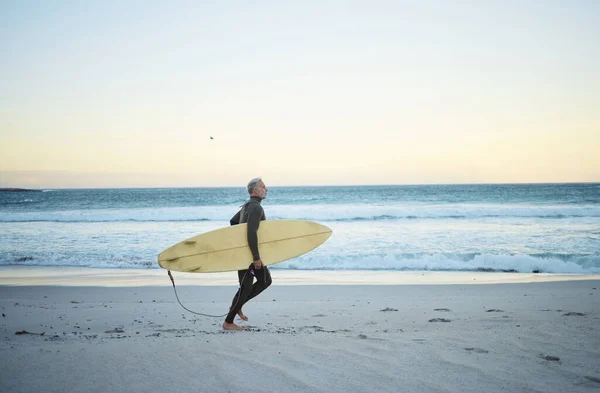 朝の屋外で海の海岸を歩くサーフボードと砂の上の男のビーチ 水とサーフィン 男性サーファーは健康的なフィットネスと休暇中の旅行のためにコスタリカでロングボードで実行しています — ストック写真