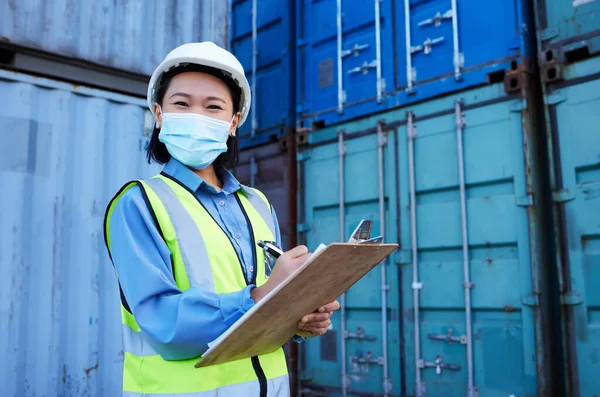 Container, covid 19 and engineer woman checklist planning cargo distribution, shipping and manufacturing logistics. Supply chain Asian manager or contractor face mask for safety and virus protection.