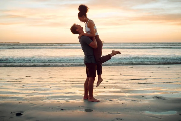 Happy couple at beach hug and love celebration on romantic sunset tropical ocean water hawaii luxury vacation travel or holiday. Woman and man dating and celebration for engagement announcement.