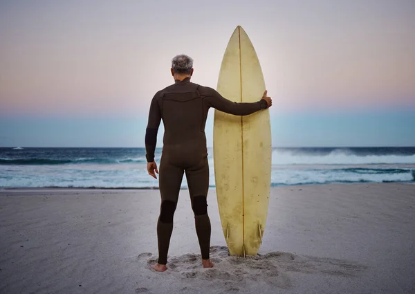 海の景色や日没の地平線を見て彼のサーフボードとビーチで男とサーフ 海とスポーツ 自然の中で水によって海に立っている男性アスリートと健康 フィットネスやスポーツ — ストック写真