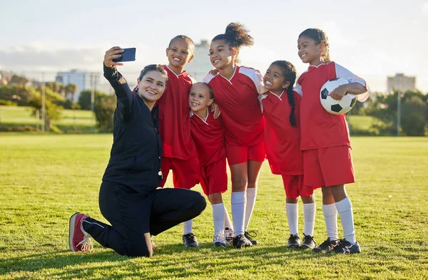 屋外で一緒にトレーニング 競争やゲームの後 サッカー場 女子チームとソーシャルメディアのためのコーチの自撮り 幸せな子供たち 笑顔の先生と学生コミュニティサッカーアカデミー写真を撮る — ストック写真