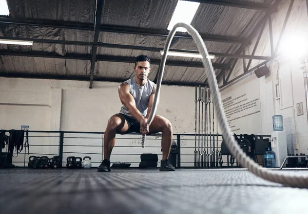 Man, workout and fitness with rope at gym for health, exercise and body wellness. Healthy, muscle and strong for development for athlete in mma, wrestling or sport at training club, class or studio.