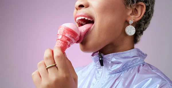 Woman, ice cream and mouth while eating pink dessert with cone against studio background. Model, zoom and lick sorbet, snack or gelato for taste in summer with professional backdrop in Los Angeles.