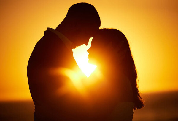 Silhouette, sunset and couple on honeymoon love bonding, hugging and enjoying quality time together in Los Angeles. Romantic woman and partner on holiday vacation in a dark night on Valentines day.