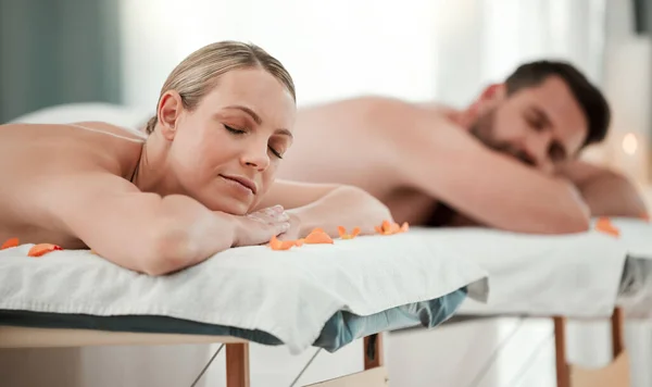 Massage, relax and wellness with a couple in a spa for treatment, health or body care while on a date. Luxury, beauty and romance with a man and woman on a bed in a clinic for rest and relaxation.