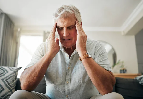 彼のリビングルームで退職 財政問題や住宅ローンについての頭痛 ストレスや不安を持つ高齢者 片頭痛の痛みや精神衛生上のリスクを持つ病気の高齢者と上のフラストレーションソファ — ストック写真
