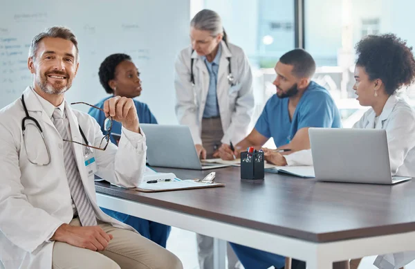 Portrait of doctor with team in a meeting in the office, having a strategy discussion. Business meeting, teamwork and leadership in healthcare, working online using computers in the medical industry.