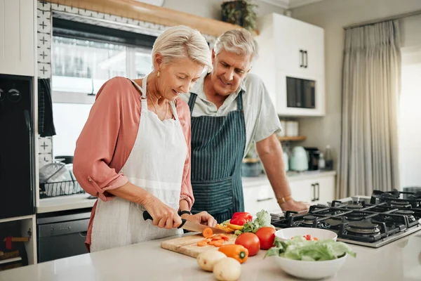 Senior couple, healthy food and cooking lunch together in Australia kitchen at home. Happy woman, hungry man and retirement people cut vegetables for nutrition diet, wellness and vegan dinner meal.