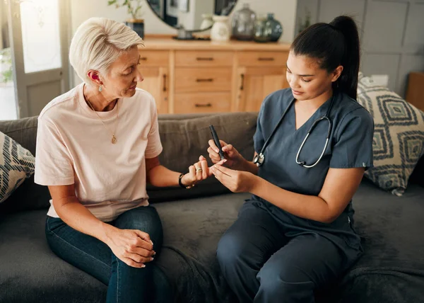 Diabetes, healthcare nurse and elderly woman finger doing blood test, sugar or medical test with a glucometer. Insurance doctor, health or diabetic senior lady consulting her glucose wellness at home.