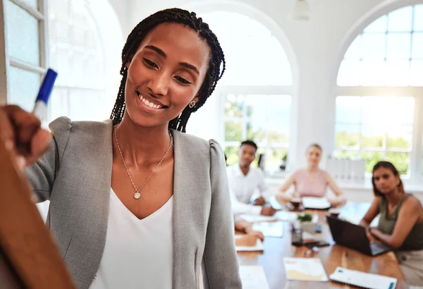 Team, black woman and brainstorming writing on board for team meeting, idea or smile for planning or strategy in office. Group, teamwork or creative conversation, talk or discuss project in workspace.