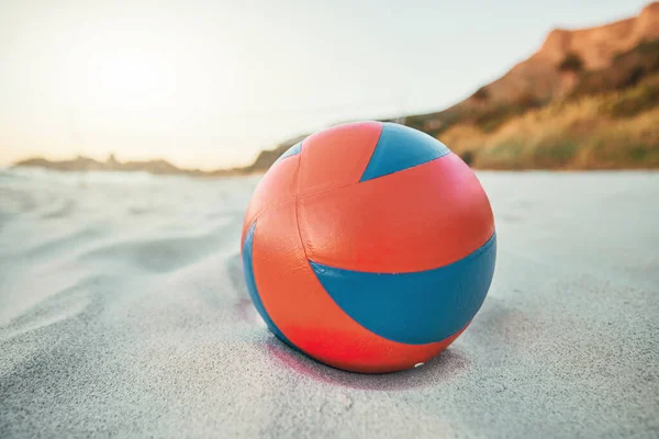 Beach, ball and volleyball on sand, a game at sunset at tropical ocean destination. Fitness, fun and summer sports at the sea in the evening. White sandy coast, a volley ball and an empty seascape