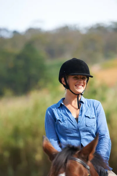 乗馬は彼女に多くの喜びをもたらします 外で馬に乗って笑っている幸せな若い女性の肖像画 — ストック写真