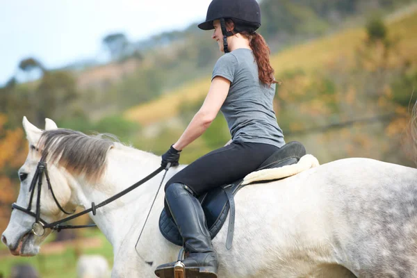 乗馬はとてもリラックスしています オープンフィールドで彼女の馬に乗って若い女性 — ストック写真