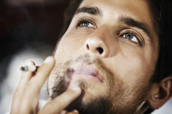 規則は彼には何の意味もない タバコの煙を吐き出すハンサムで思慮深い若者の閉鎖 — ストック写真