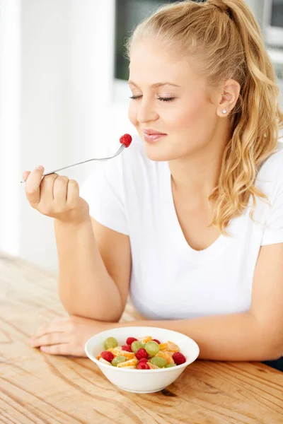 健康的な食事療法に従うことを選択 魅力的な若いです女性食べるフルーツサラダで彼女のキッチン — ストック写真