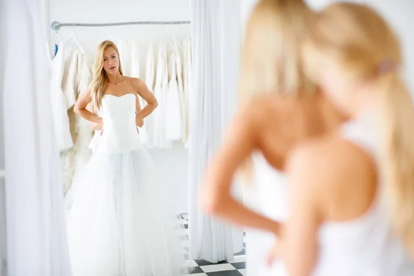 看得更清楚些一位年轻的新娘在选择婚纱时 照着镜子里的倒影 — 图库照片