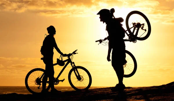 日落骑手 一对夫妇在海滩上骑自行车的轮廓 — 图库照片