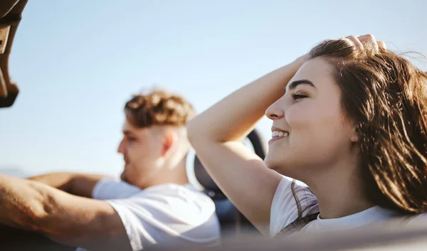 Love, couple and in car on road trip while travel, adventure and enjoy summer wind being romantic, smile and happy together. Romance, man and woman on vacation, holiday or fun while relax or bonding.