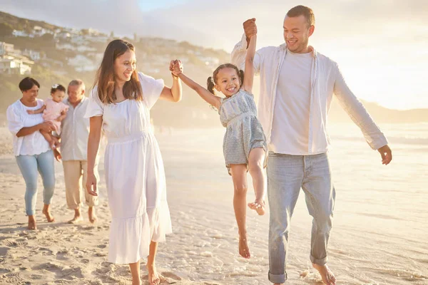 両親と手を取りながら揺れる可愛い女の子 幼い母と日は娘と手を携えて歩き ビーチを歩いている間に彼女を持ち上げる 夏の太陽の下で家族の楽しみ — ストック写真