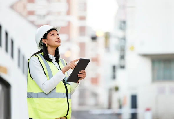 Woman, building manager and construction on tablet doing inspection and working on site in the city. Female architect or builder contractor checking architecture at work on touchscreen technology.