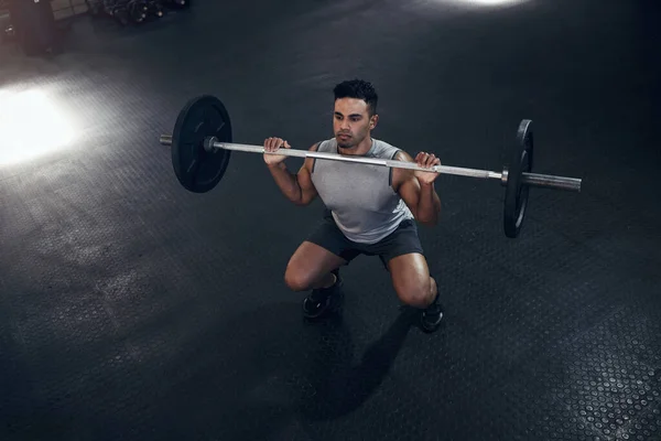 Barbell exercise, gym man and sports training, workout and fitness of heavy weights press in health club. Above of indian bodybuilder, serious male athlete and body muscle, power or strong motivation.