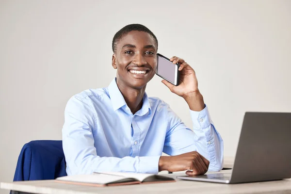 Businessman, smile and phone for call at desk with laptop for reading communication, email or report on the internet. Black man, happy and working in office with green screen phone in at table.