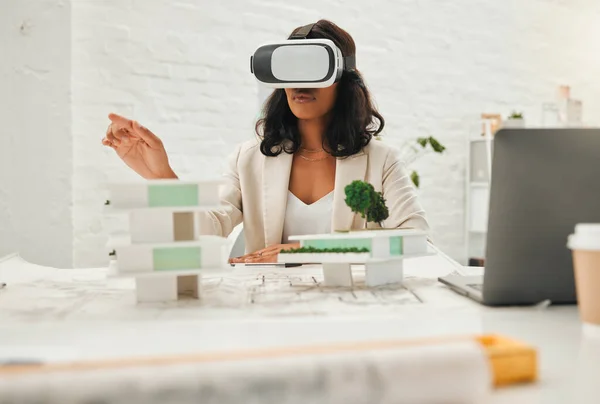 Young designer using AI simulator to plan building. African American architect using VR goggles.Young engineer using a virtual reality headset in her office. Businesswoman playing a fun game.