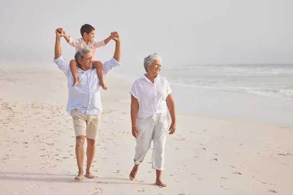 혼혈아 조부모가 손자와 해변을 소년은 할아버지 어깨에 해변에서 방학을 즐긴다 — 스톡 사진