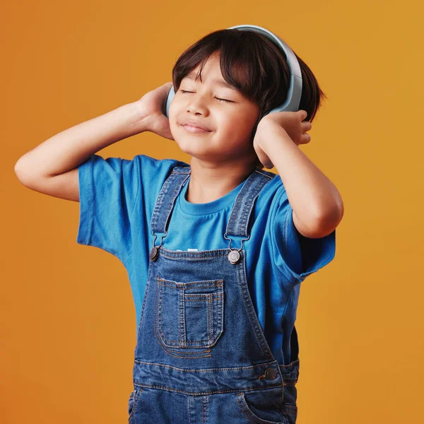 Uroczy Mały Azjatycki Chłopiec Słuchający Muzyki Słuchawkach Pomarańczowym Tle Copyspace — Zdjęcie stockowe