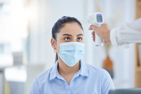 Woman, covid 19 and thermometer for safety, health and sign of infection. Doctor, patient and technology in face with mask for wellness, protection and stop of coronavirus sickness in Los Angeles.