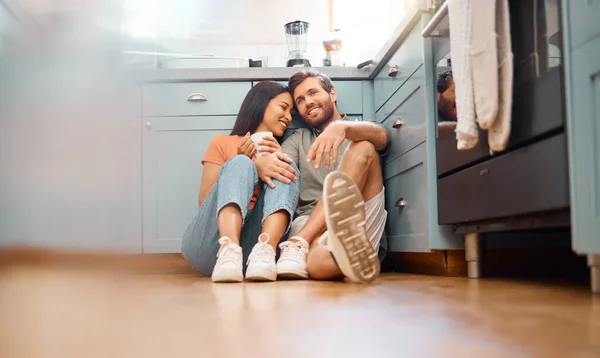 年轻快乐的跨种族夫妇在一起喝咖啡的时候在家里结合在一起 可爱的高加索男友和混血的种族女友坐在厨房地板上 快乐的丈夫和妻子放松一下 — 图库照片