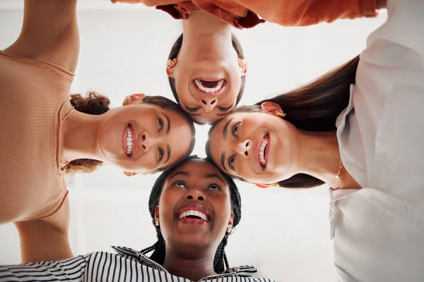 4人の幸せなビジネス女性が職場のオフィスで輪になって頭を合わせています 明るいビジネスマンの多様なグループが団結して彼らの頭と一緒に立って楽しんでいる — ストック写真