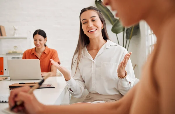 Confident young hispanic business woman speaking to colleagues during a meeting in an office boardroom. Happy staff sharing feedback and explaining ideas while brainstorming in a creative startup age.
