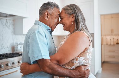 Sarılın, sevin ve emeklilik için gülümseyin, evlenin ya da evlerinin mutfağında destek olun. Mutlu ve yaşlı bir adam ve kadın yıldönümlerinde evlerinde kucaklaşıyorlar..