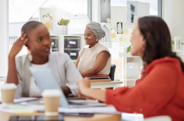 Smiling ambitious african american business woman sitting and working in office. Confident focused ethnic professional sitting behind team of colleagues. Determined to be successful women in business.