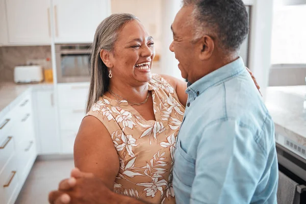 Senior couple dance in kitchen with celebration for retirement, real estate or happy marriage. Elderly pension people dancing to music with love, care and wellness in their house or home together.