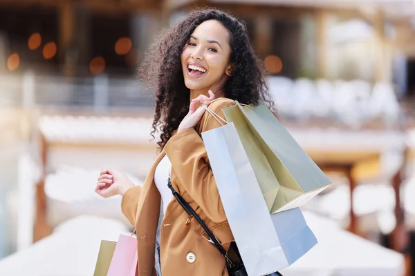 Shopping, happy and portrait of customer with bag after shopping spree buying retail fashion product on store discount. Sales, smile and young black woman at luxury shopping mall to purchase clothes.