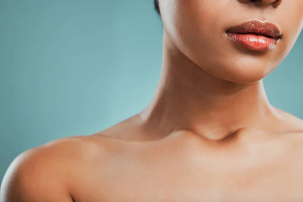 Closeup view of a mixed race woman posing against a green background. Female showing her healthy smooth soft skin in a studio.