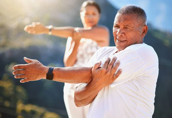 在阳光明媚的日子里 老年人在室外锻炼时伸出手来 在大自然中 成熟的人们一起练习瑜伽 在退休期间保持健康和活跃 戴着智能手表 — 图库照片