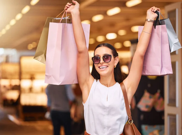 一名年轻的男女混血女子戴着太阳镜 在商场购物狂欢时举着展示袋的肖像 西班牙裔女性在兴奋的同时享受零售治疗 Shopaholic Holdin — 图库照片