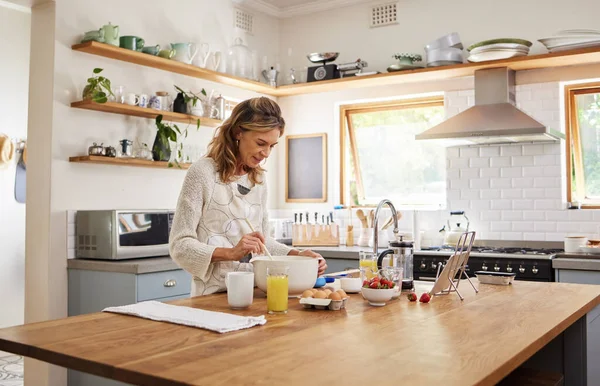 Cooking, tablet and senior woman with recipe for food on the internet while in the kitchen of her house. Happy elderly chef with digital information for breakfast, lunch or dinner in her house.