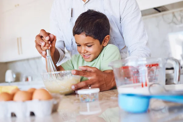 Baking, kid and father in kitchen learning to make cake, cookies or biscuits in home. Support, care and bonding with parent teaching boy how to cook, bake and cooking with eggs, wheat flour and milk.
