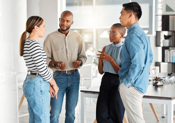 Group of diverse businesspeople having a meeting in a modern office at work. Business professionals talking and sharing ideas. Businesspeople planning together.