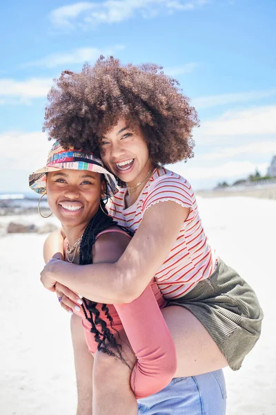 Girl friends, piggy back and women on the beach sand on vacation or summer holiday. Sunshine, ocean and a happy weekend in the sun, portrait of black woman and friend having fun at the sea together