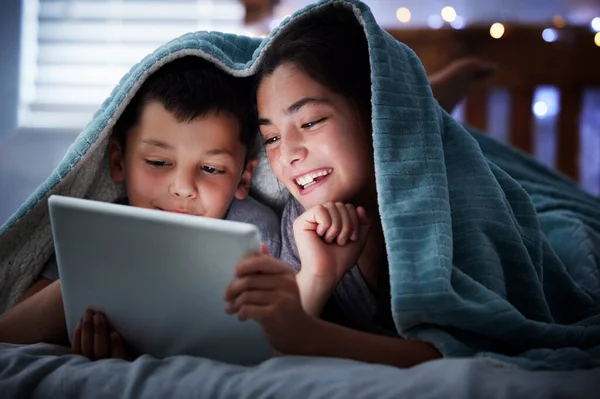 Δύο Παιδιά Κρατώντας Ψηφιακή Ταμπλέτα Ενώ Βρίσκεται Κάτω Από Κουβέρτα — Φωτογραφία Αρχείου