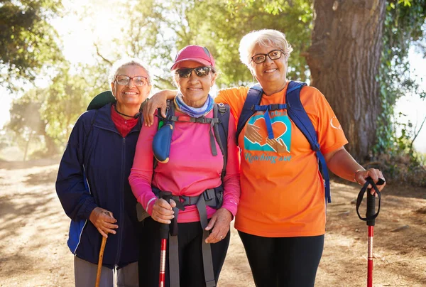 Senior women, hiking group and friends fitness in nature, park and forest for healthy lifestyle, wellness and freedom together. Portrait happy, elderly and retirement people walking exercise outdoors.