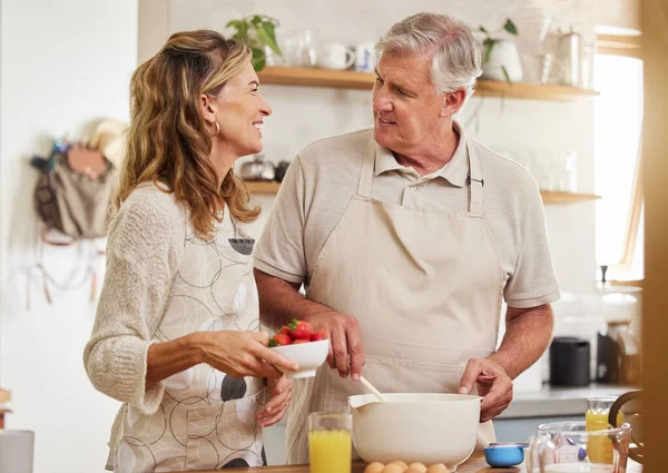 年事已高 夫妻二人在厨房里 烤着草莓 在家里快乐地在一起 年长的男人 女人和退休人士在家里笑着 一边聊天 一边学做饼干 蛋糕或甜点 — 图库照片